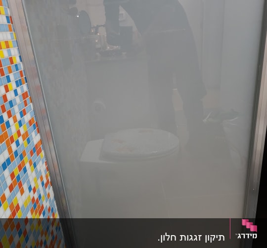 דלת זכוכית חלבית עם קיר פסיפס צבעוני